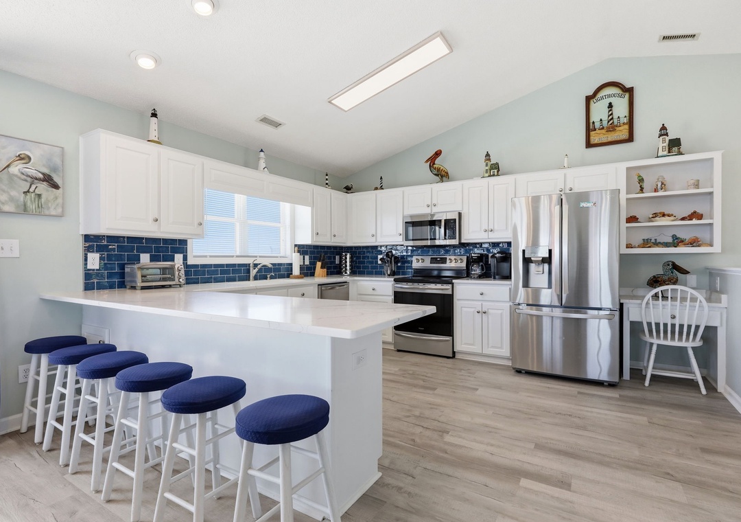 Gather around the spacious island with seating for five in this bright, coastal-inspired kitchen where you'll love preparing meals with modern appliances and ample counter space.