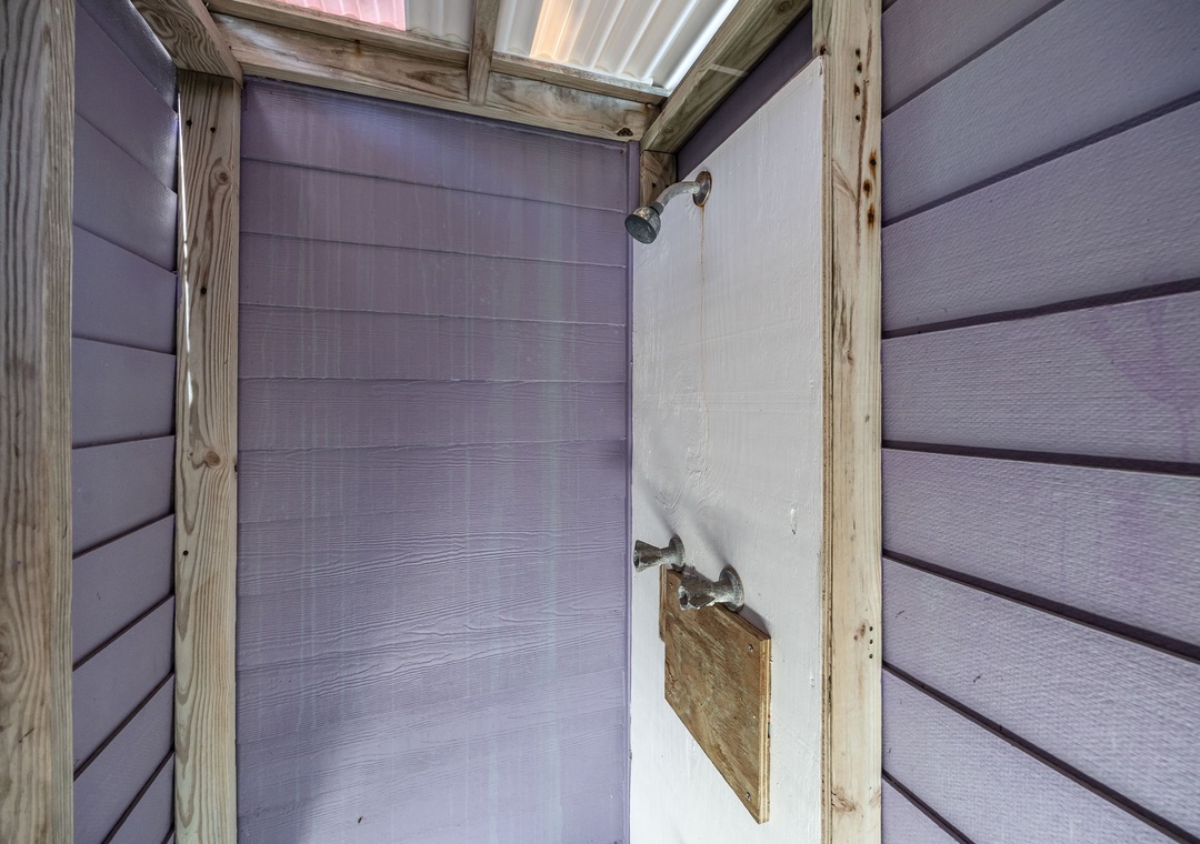 Your private outdoor shower lets you rinse off under the open sky, surrounded by natural wood walls.