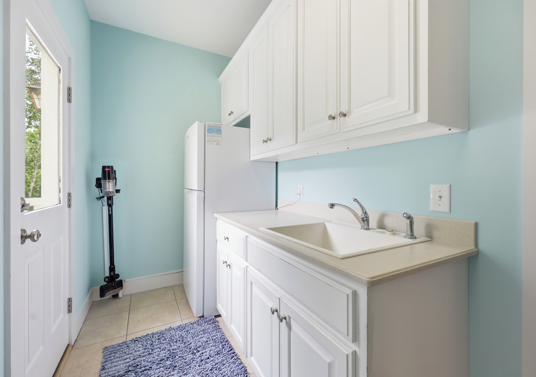 A practical laundry room with modern appliances and ample cabinet storage, making it easy to keep your wardrobe fresh during your stay.