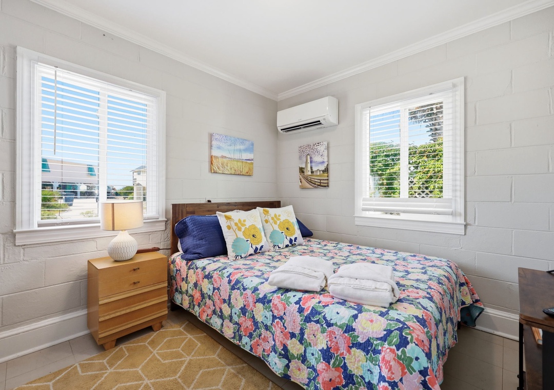 Slip into your cozy bedroom where soft linens, cheerful coastal accents, and gentle natural light create a peaceful retreat after a day of exploring.