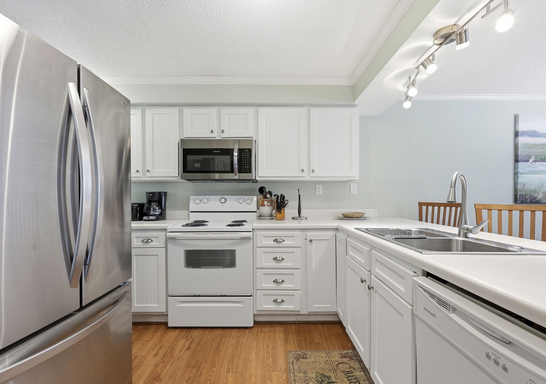 Your fully equipped kitchen features white cabinetry, stainless steel appliances, and modern conveniences—perfect for preparing home-cooked meals during your stay. Cook, dine, and gather in this bright, welcoming space.