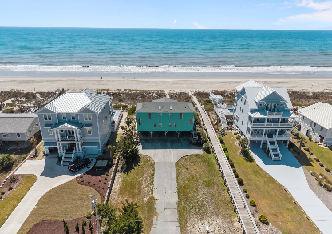Oceanfront vacation homes positioned just steps from pristine sandy beaches with turquoise waters stretching to the horizon.
