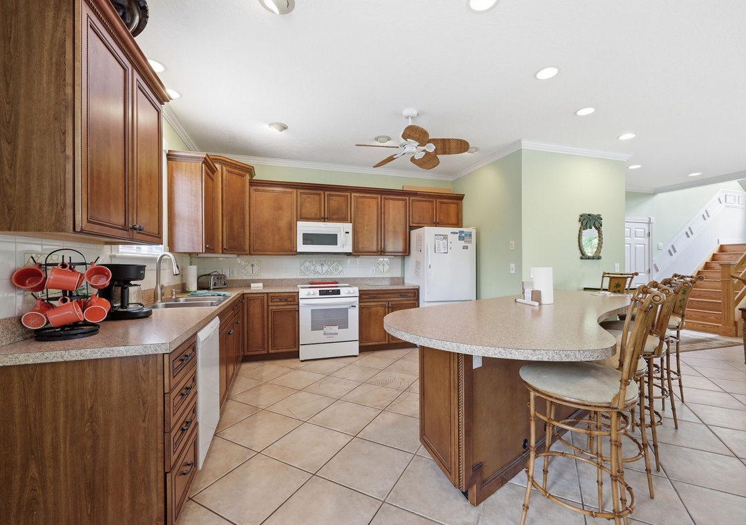 Picture yourself preparing meals in this spacious kitchen with warm wood cabinetry, granite counters, and a welcoming island with seating—perfect for morning coffee or gathering with loved ones.