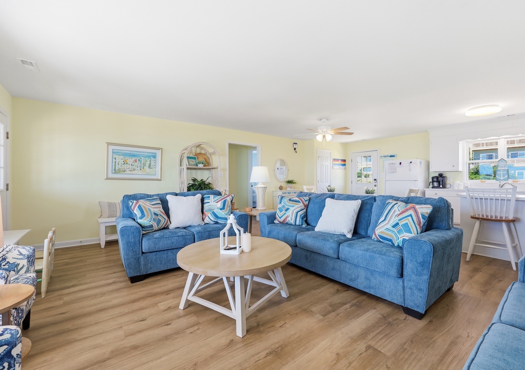 Step into your bright, cheerful living room where coastal blues meet buttery yellow walls. Sink into plush sofas, gather around the coffee table, and feel the ocean breeze from nearby waters.