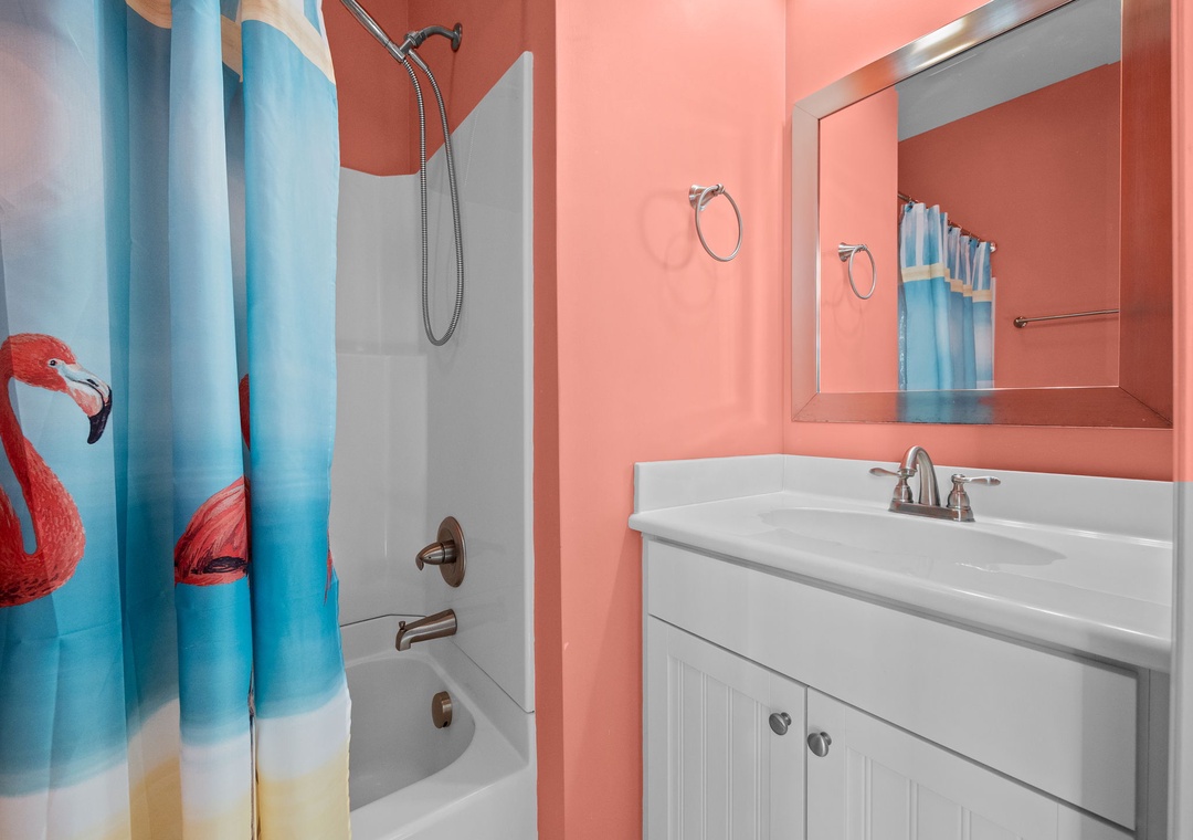 Refresh in your vibrant coral bathroom featuring a tropical flamingo shower curtain and modern amenities.