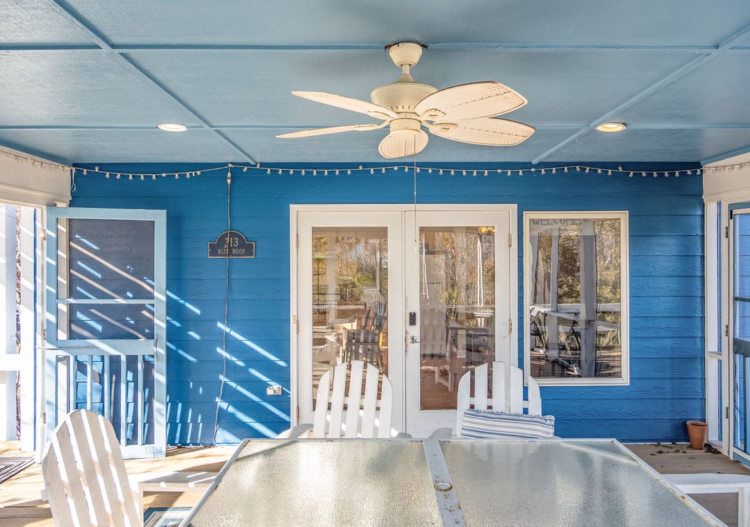 Your covered porch offers the perfect spot to unwind with coastal breezes and sparkling sunlight filtering through white railings.