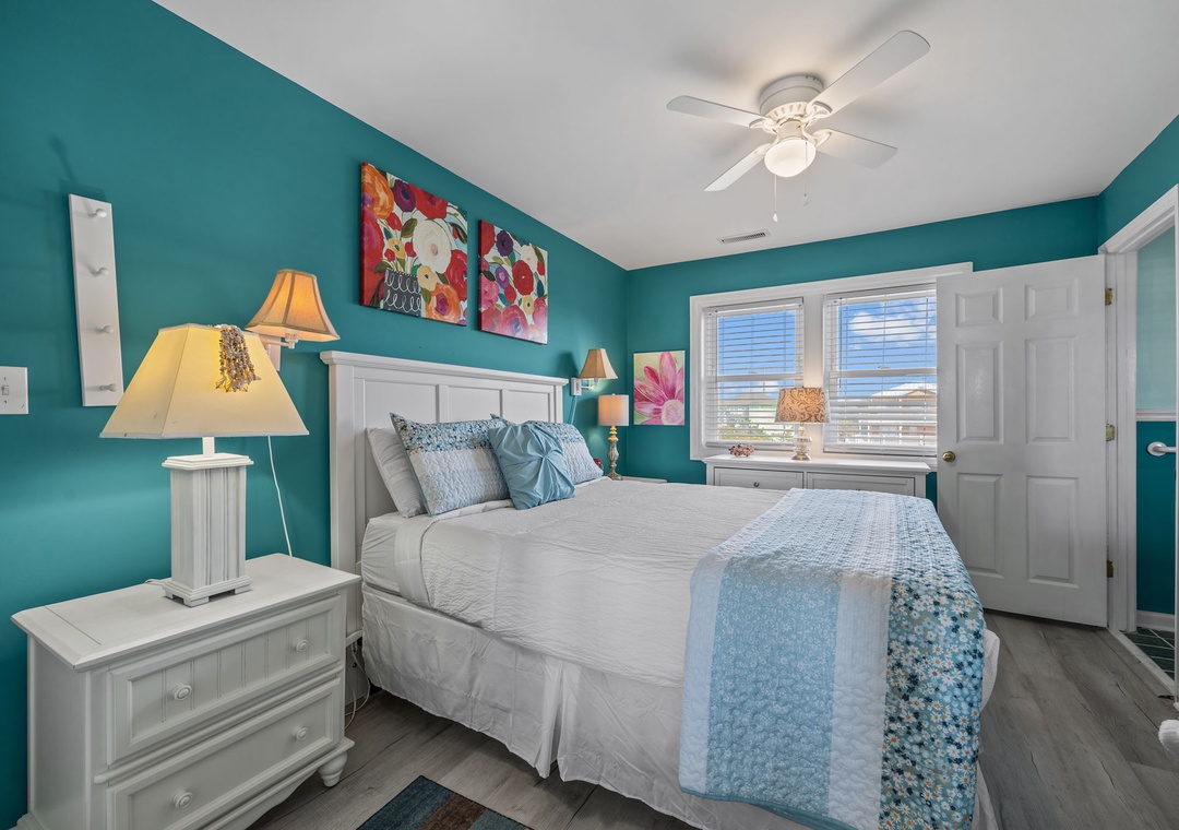 Unwind in your vibrant teal bedroom where soft blue linens and warm lamps create a peaceful retreat.