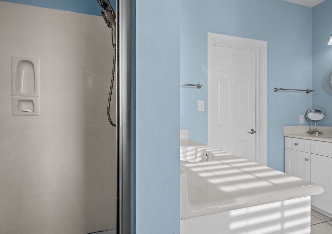 Your private bathroom features soothing blue walls, a spacious soaking tub, and a refreshing shower—perfect for unwinding after exploring.
