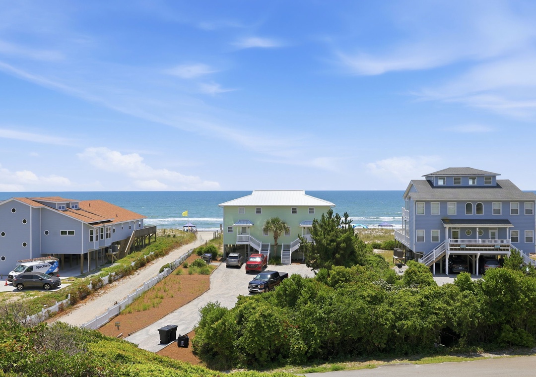 Beachfront vacation homes offer direct access to sandy shores and ocean views, surrounded by coastal greenery and just steps from the water's edge.