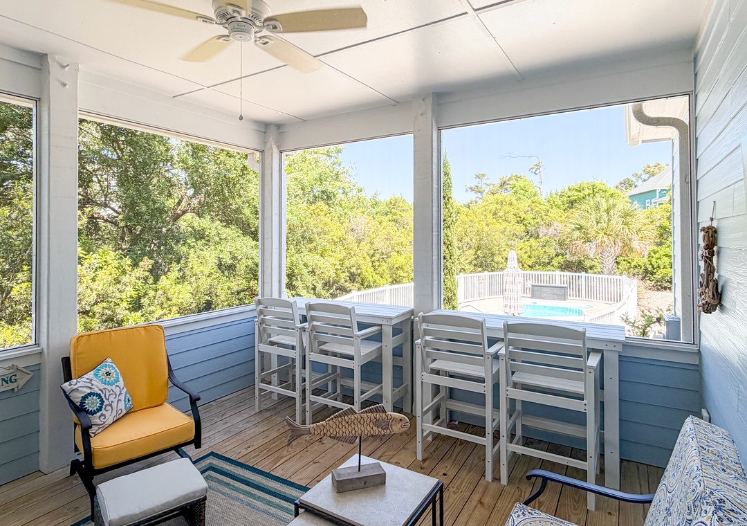 Picture yourself gathered around the dining table with loved ones, the ceiling fan gently circulating the breeze as sunlight streams through expansive windows framing lush trees and your private pool just beyond the glass.