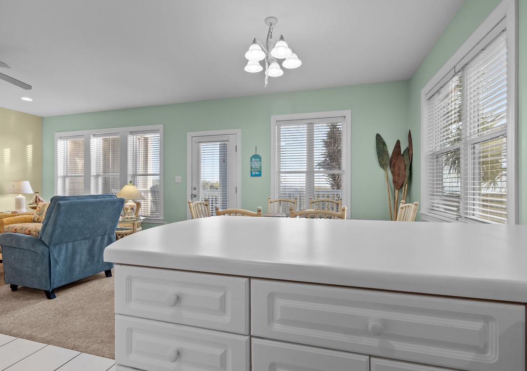 Gather around your bright dining area, where soft green walls and natural light create the perfect setting for morning coffee or evening meals.