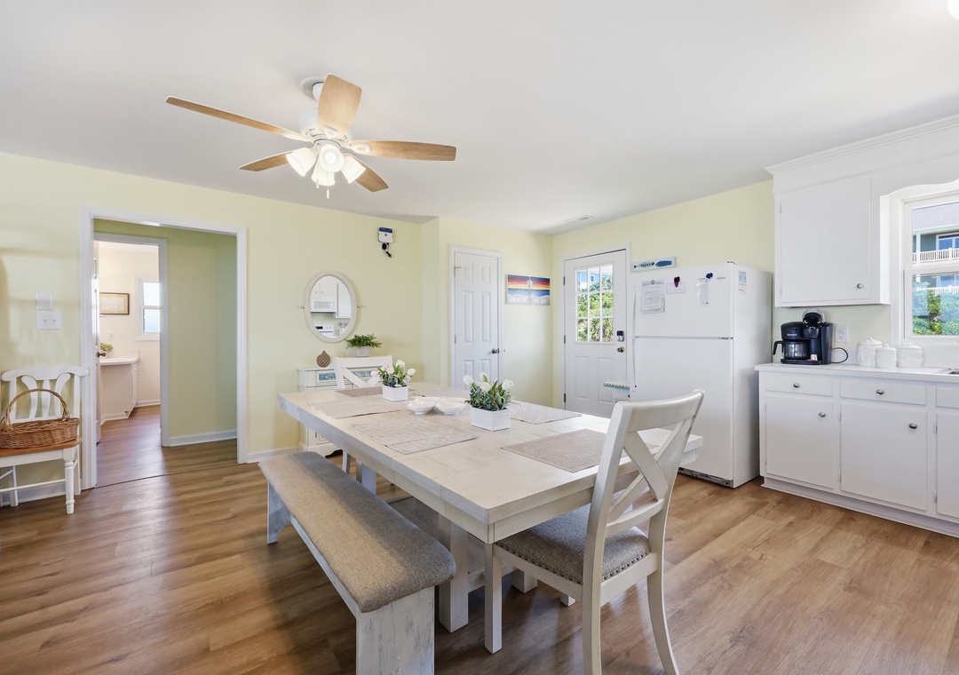 Gather around the welcoming dining table where morning coffee and home-cooked meals become cherished memories. Soft yellow walls and coastal touches create a cheerful, relaxed atmosphere for your group.
