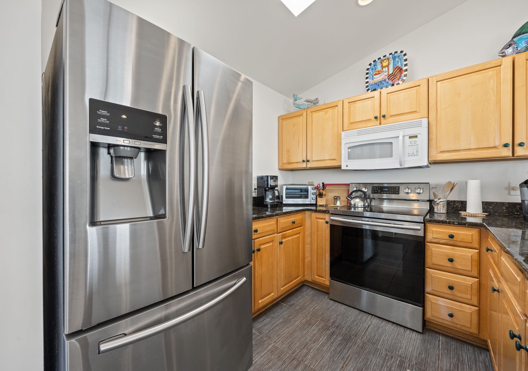 Your fully equipped kitchen features stainless steel appliances and warm wood cabinetry, perfect for preparing memorable meals during your stay.