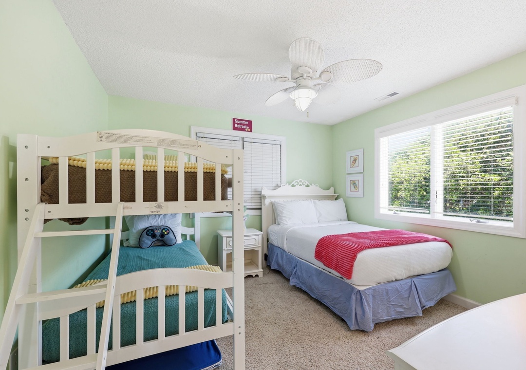 Step into a cheerful bedroom designed with both comfort and fun in mind. Soft mint-green walls create a calming atmosphere, while the bunk bed and queen bed offer flexible sleeping arrangements for your family or group.