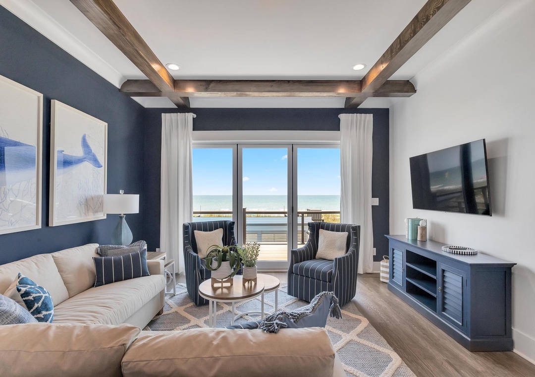 You'll love unwinding in this coastal living room, where rustic beams frame stunning ocean views beyond your private balcony. Sink into soft seating after a day at the beach and enjoy the calming palette of blues and creams.