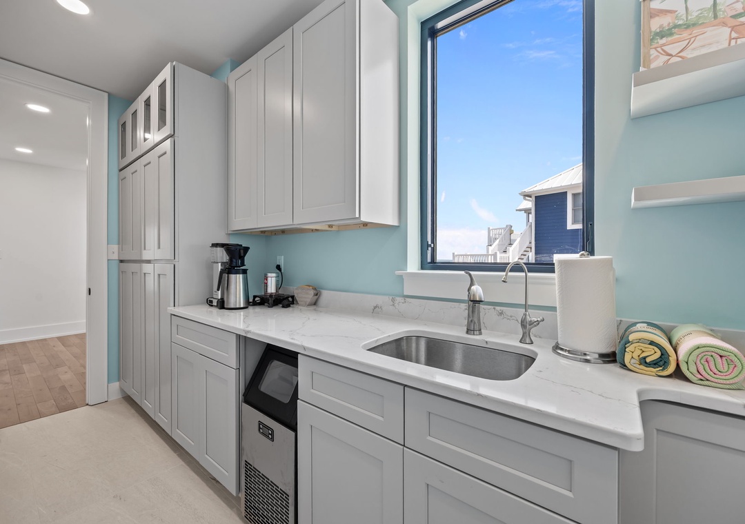 Your modern kitchen features marble countertops, stainless appliances, and coastal views through large windows.
