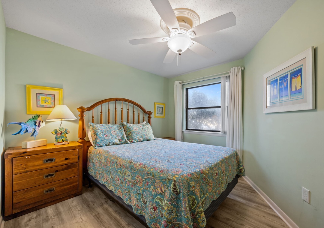 Your peaceful bedroom features a comfortable bed with charming coastal-inspired linens and soothing sage walls that invite restful sleep.