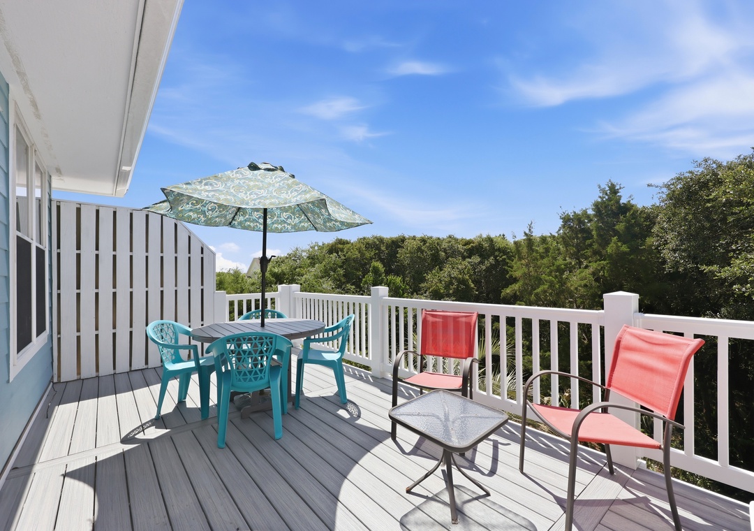 Expansive deck offering serene views of natural surroundings, with outdoor dining and lounge areas perfect for morning coffee or sunset gatherings.