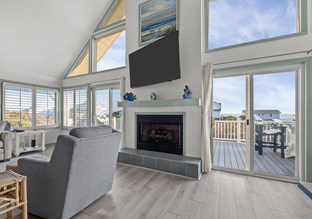 Relax in your bright living room with soaring ceilings, cozy fireplace, and sweeping views through floor-to-ceiling windows.