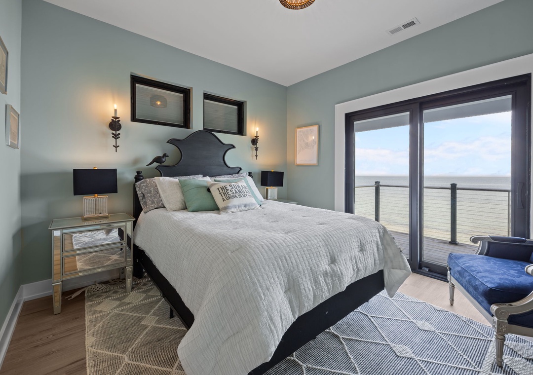 Wake up to endless ocean views from your private balcony in this serene coastal bedroom retreat.