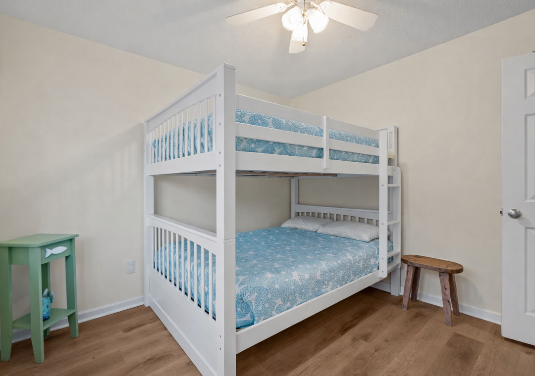 Your kids will love this cheerful bunk bed room with ocean-blue bedding and warm wood floors for comfortable sleeps.