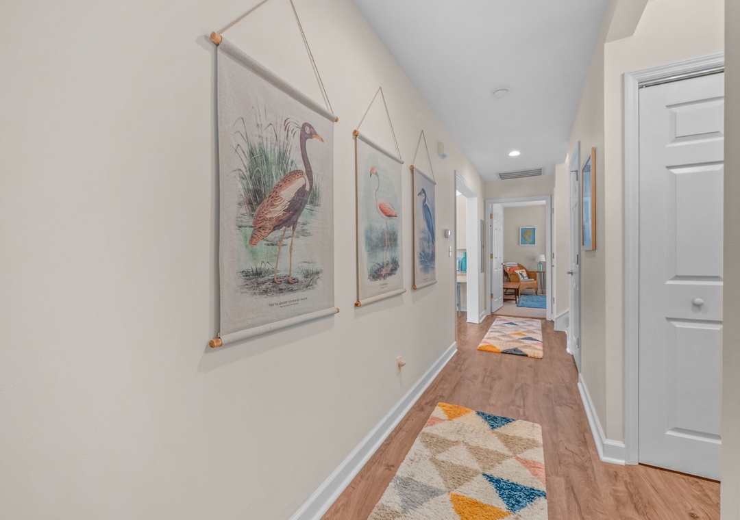 Bright hallway adorned with charming bird prints guides you between your comfortable living spaces.