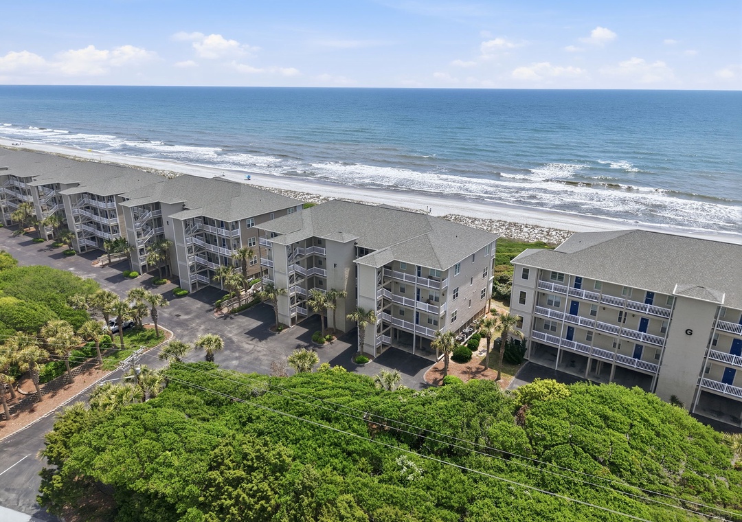 Beachfront resort property positioned directly on the sandy shore with gentle waves rolling in from the expansive Atlantic Ocean.