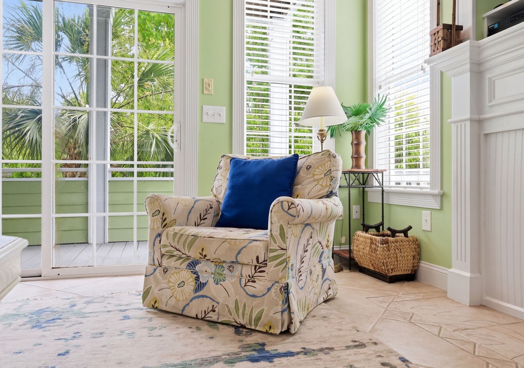 Curl up in your cozy reading nook with natural light pouring in through French doors, overlooking tropical palms and gentle breezes—a perfect spot to unwind.
