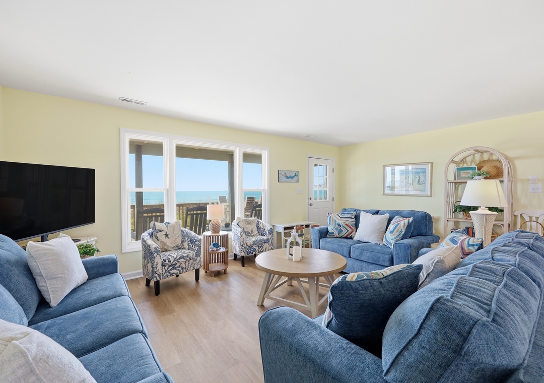 Your coastal escape awaits—imagine relaxing on plush sofas as ocean breezes drift through expansive windows, framing stunning sea views and inviting you to unwind completely.