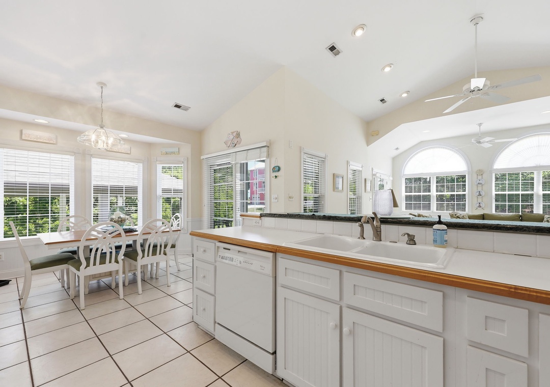 Step into your bright, airy kitchen and dining space where natural light pours through generous windows. White cabinetry and warm countertops create a welcoming spot to cook and gather.