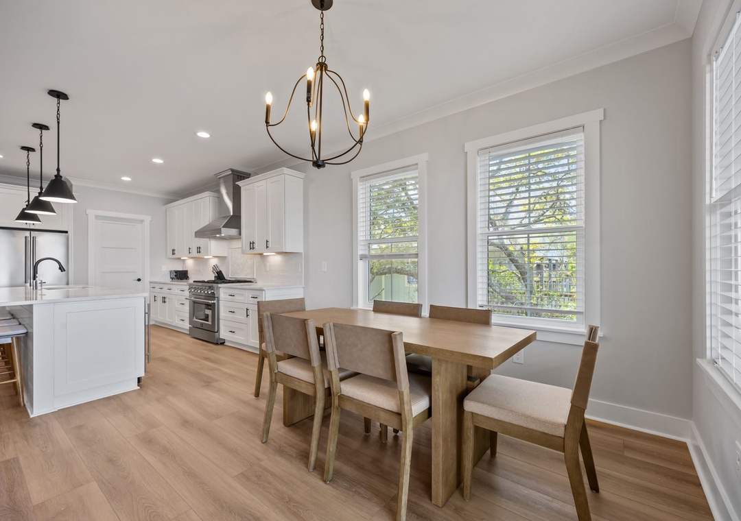 You'll love gathering around this elegant dining table in your bright, modern kitchen with premium appliances and charming chandelier overhead.