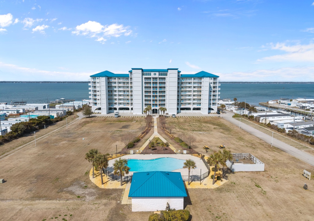 Oceanfront resort building featuring outdoor pools and direct beach access in a coastal community setting.