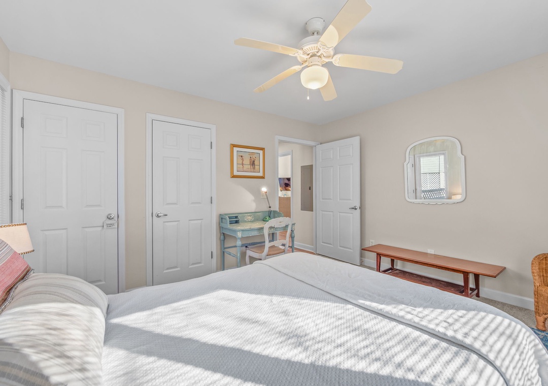 Your peaceful bedroom features a comfortable bed with soft linens, charming desk workspace, and ceiling fan to keep you cool.