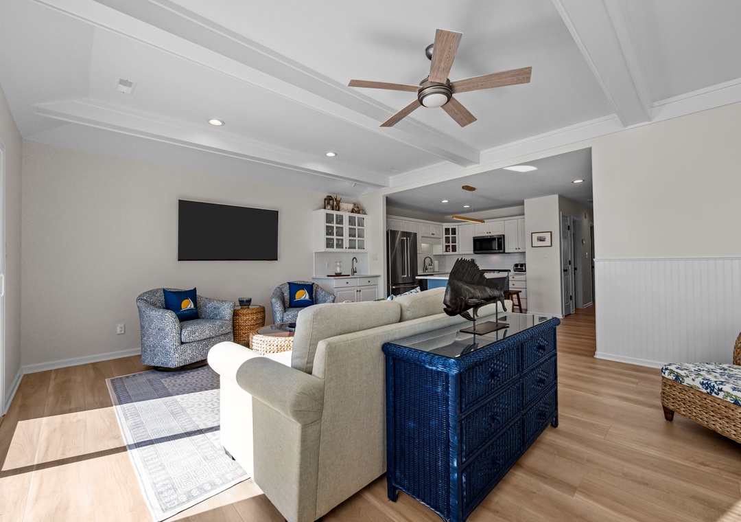 Relax in your beautifully appointed living room with soaring coffered ceilings, coastal-inspired furnishings, and an open flow to your fully equipped kitchen.