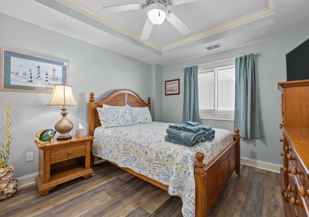 Your coastal-themed bedroom offers comfort with a ceiling fan, nautical decor, and soft linens for restful nights.