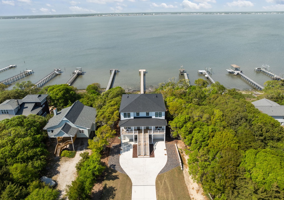 Stunning waterfront property nestled among mature trees with private dock access and panoramic bay views.
