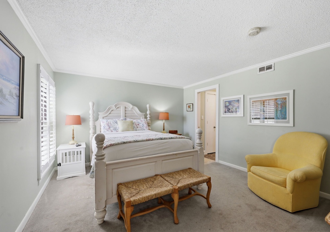 Sink into soft coastal comfort in your serene bedroom, where a charming four-poster bed, cozy seating, and soothing colors create your perfect retreat.