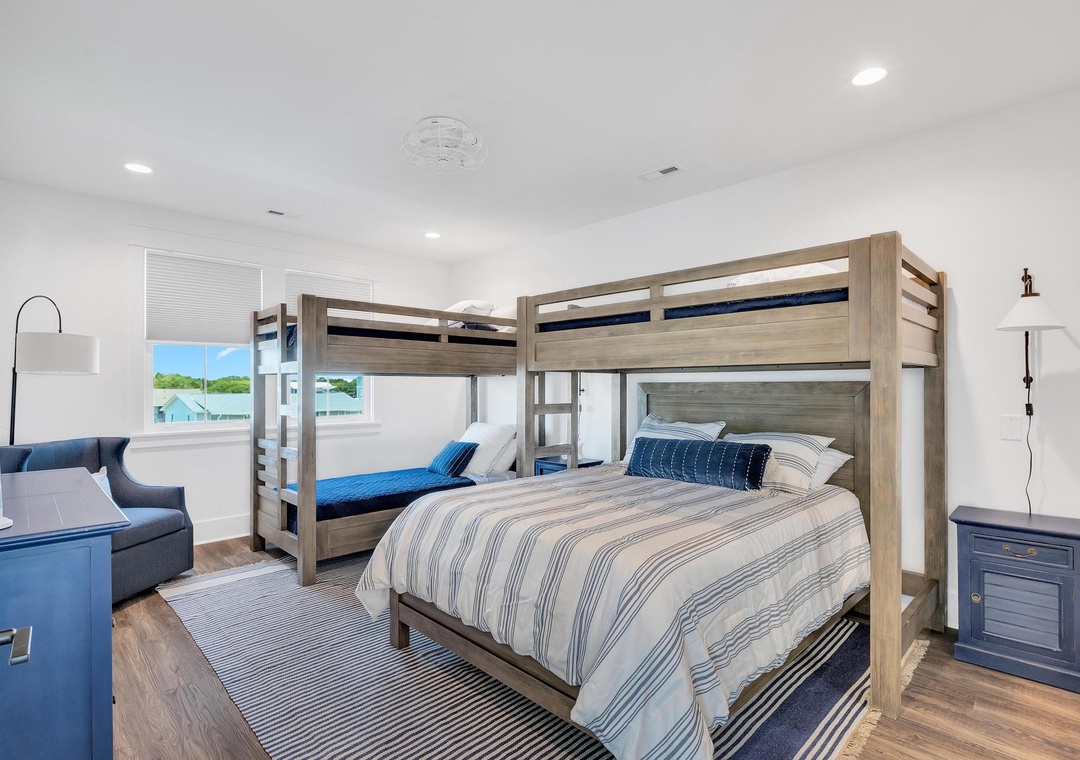 Gather the whole crew in this coastal-inspired bedroom, where two sturdy bunk beds with nautical-striped bedding create cozy sleeping nooks for everyone.