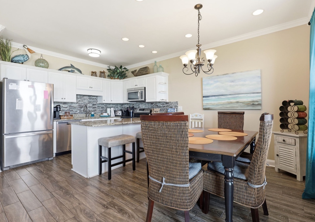 Your fully equipped kitchen flows into a welcoming dining space, perfect for preparing fresh meals and gathering together. Coastal touches and modern appliances make cooking a breeze during your stay.