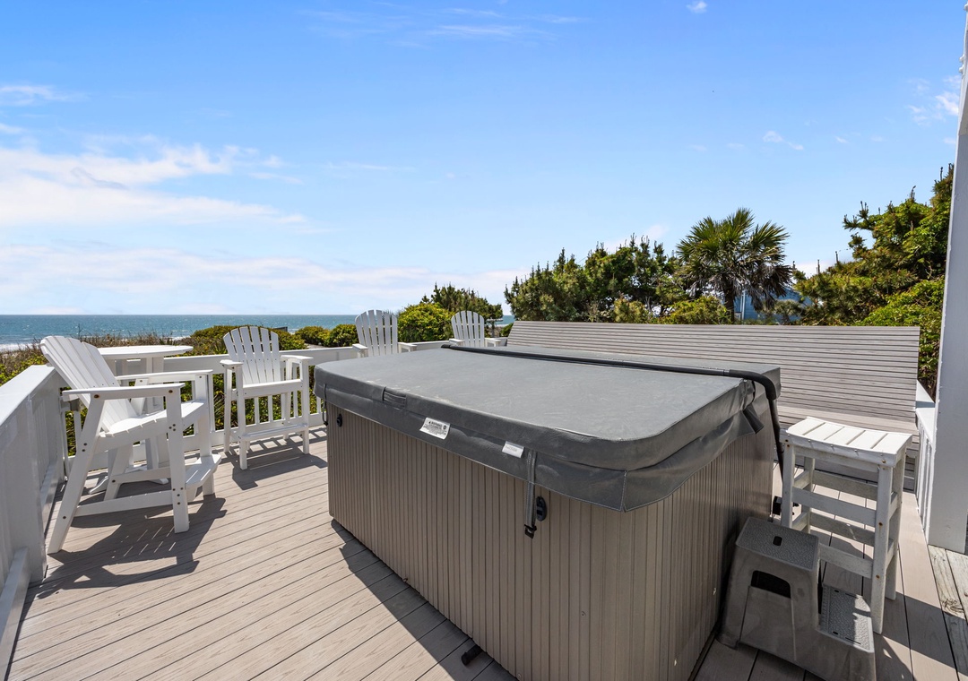 Spacious deck features a covered hot tub and oceanfront seating, perfect for relaxing while enjoying coastal breezes and sea views.