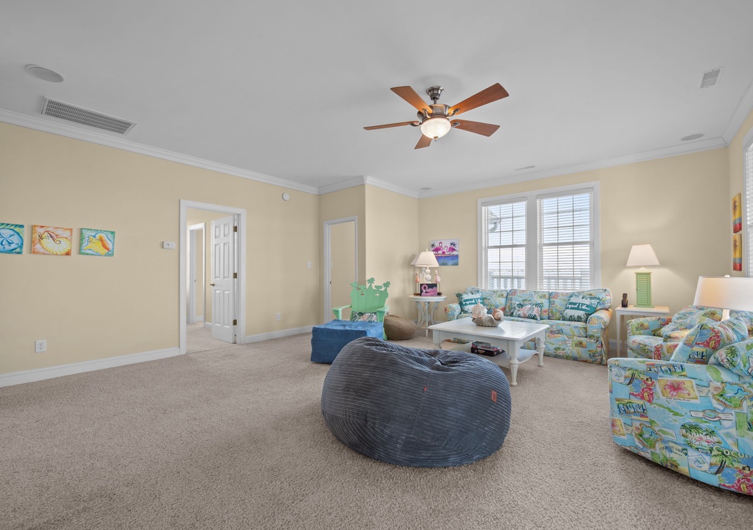 Relax in your spacious living room with tropical-themed furniture and a cozy bean bag for casual lounging.