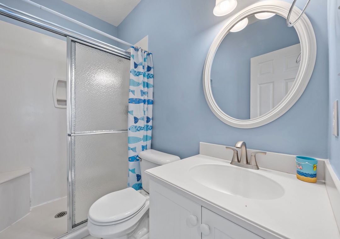 Refresh yourself in this cheerful bathroom with its soothing blue walls, spacious shower, and coastal-themed touches that make your morning routine feel like a seaside retreat.