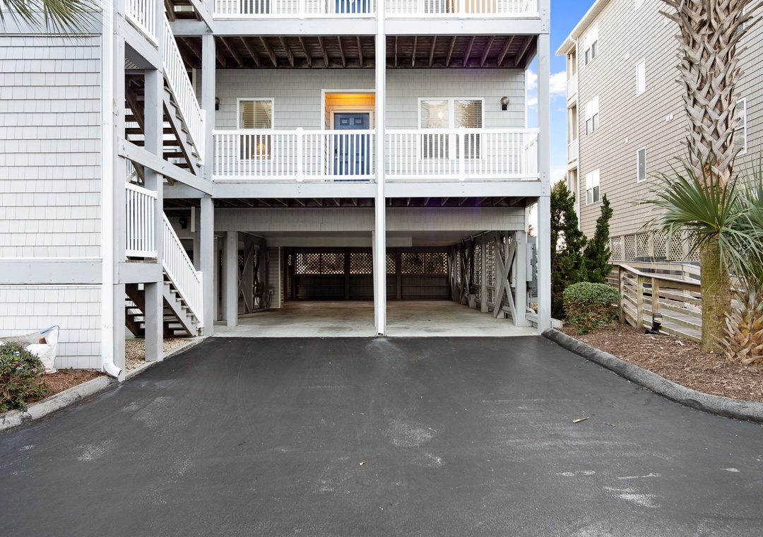 Covered parking garage with space for two vehicles beneath this coastal vacation rental property.