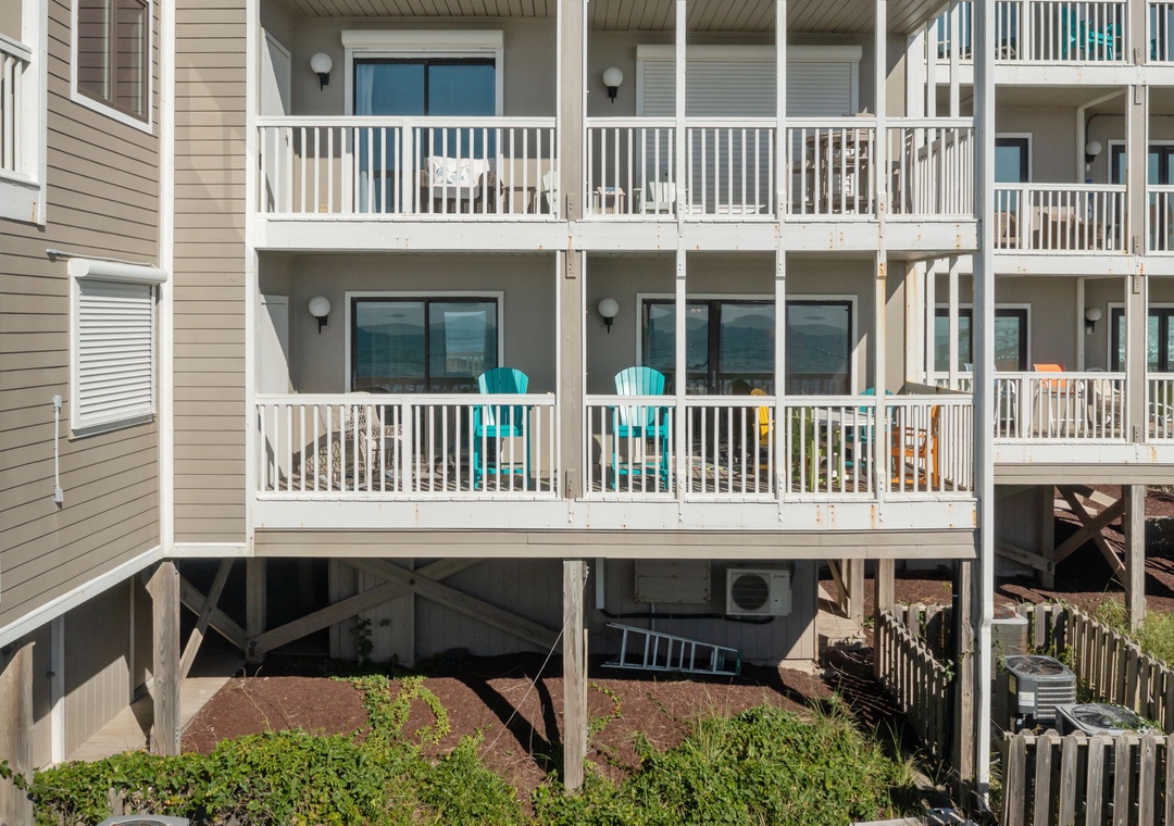Step onto your private balcony with turquoise chairs, perfect for morning coffee or evening relaxation overlooking the peaceful grounds.