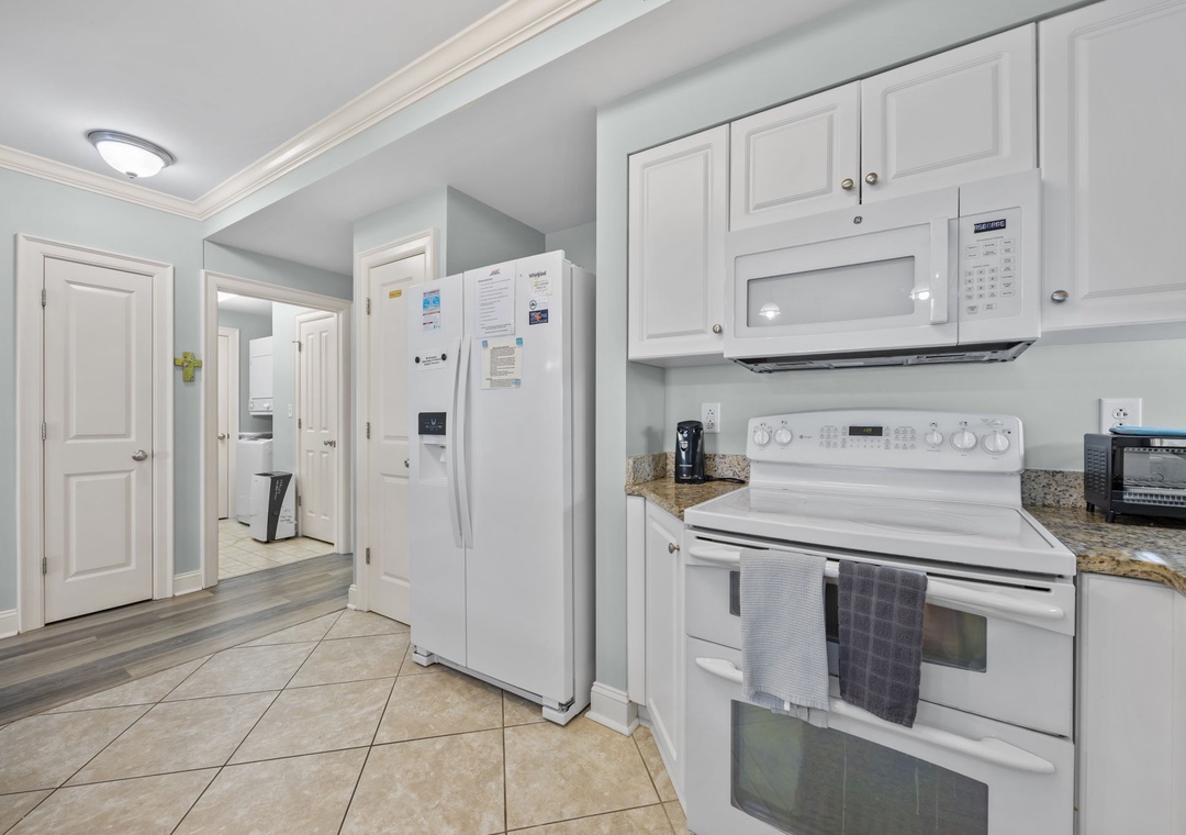 Your fully equipped kitchen awaits with granite counters, white appliances, and everything you need to create memorable meals during your stay.