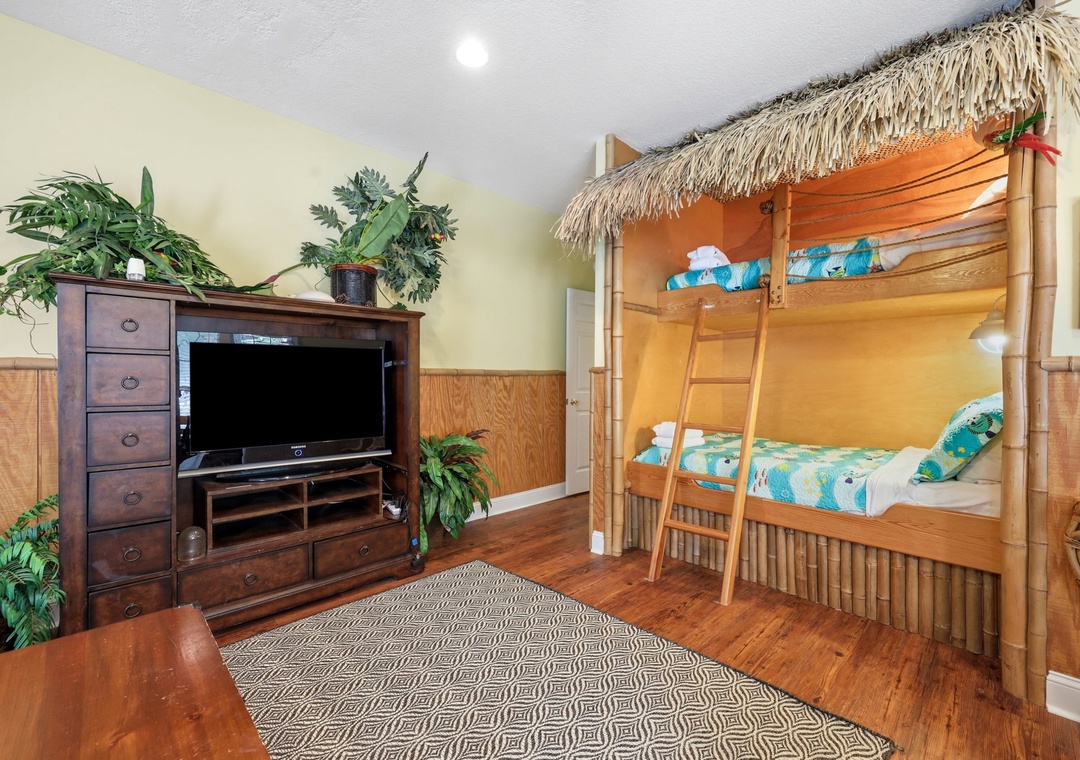 Your island-themed bedroom features a fun tiki-hut bunk bed and tropical touches that'll delight the whole family. Cozy hardwood floors and a TV complete the playful escape.