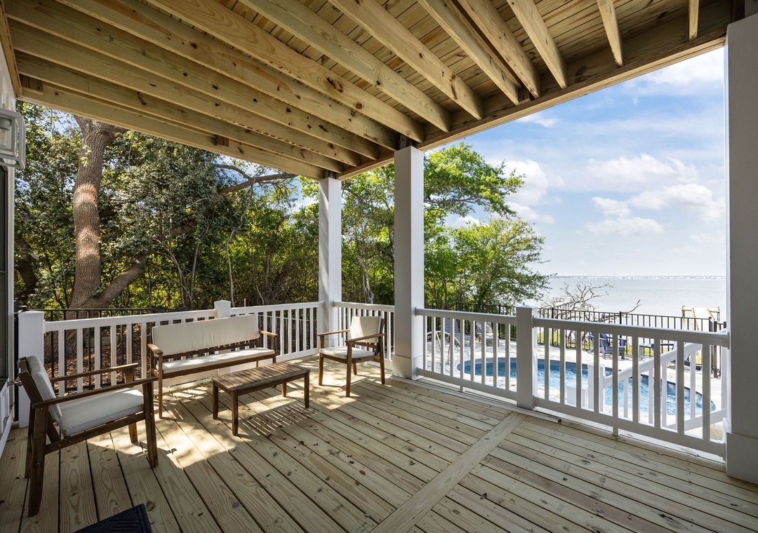 Your private balcony offers serene pool and water views through the trees, where morning coffee feels magical.