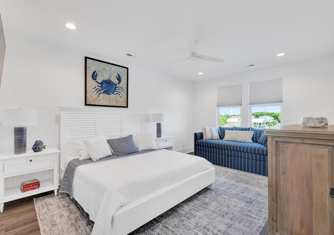 Sink into crisp white linens and coastal charm in your serene retreat, where nautical touches and a plush sofa invite you to unwind completely.