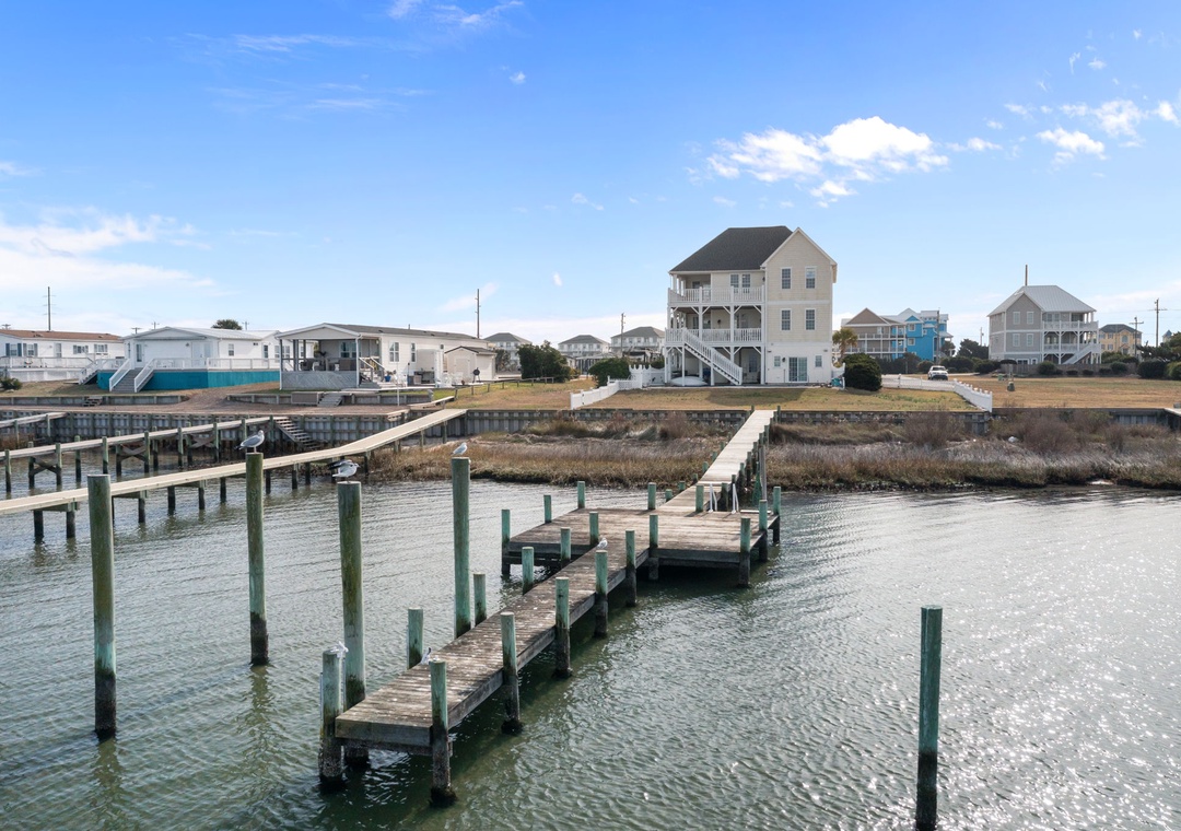 Waterfront community with private docks and boat slips along the canal, featuring coastal homes with elevated designs.