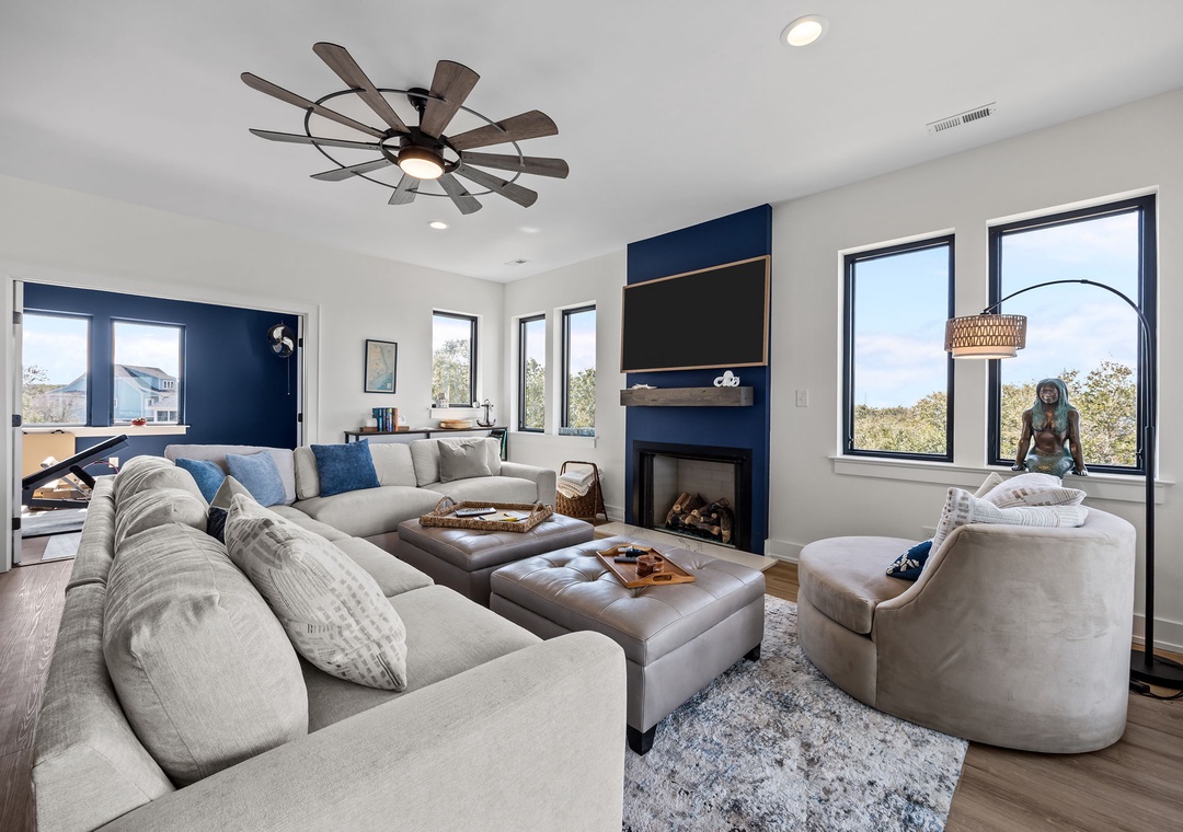 Sink into plush sectional seating while your favorite show plays on the wall-mounted TV, with a cozy fireplace nearby.